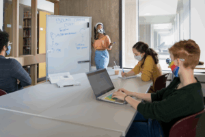 Students sitting around a table in a study room at Michener Library