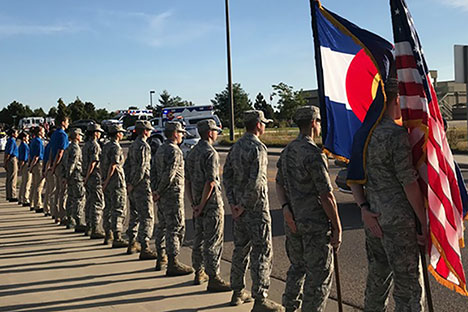 Cadets holding American and Colorado flags. 