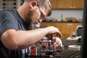 Student working hands-on on a robotics project.