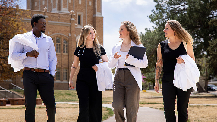 Osteopathic medical students pose on campus.