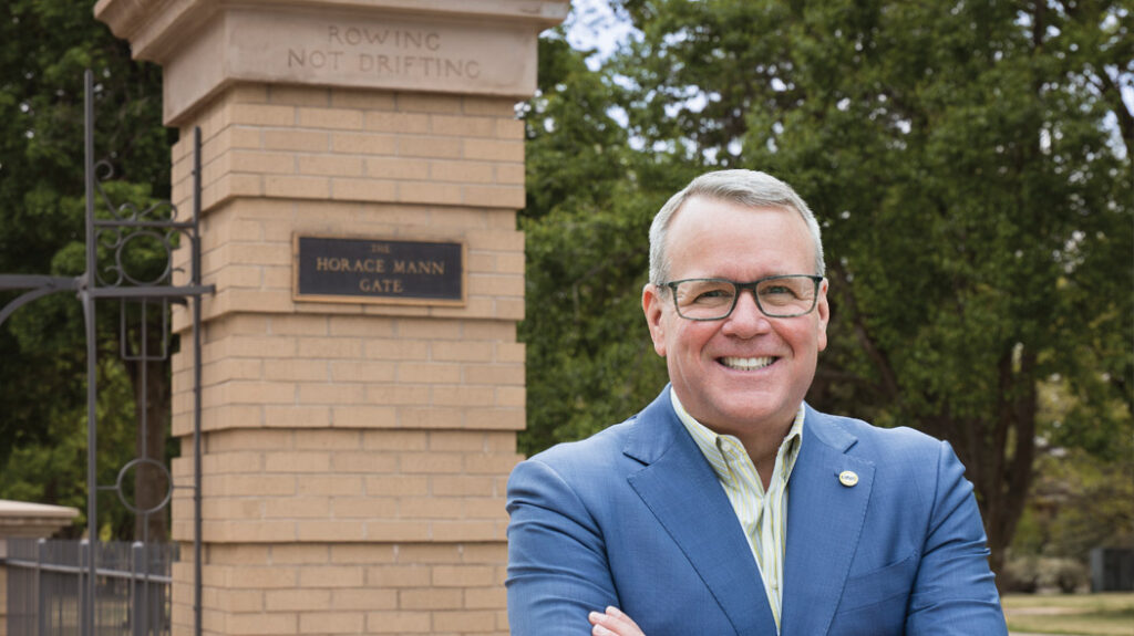 Andy smiling and standing in front of the Horace Mann gates on Central Campus.