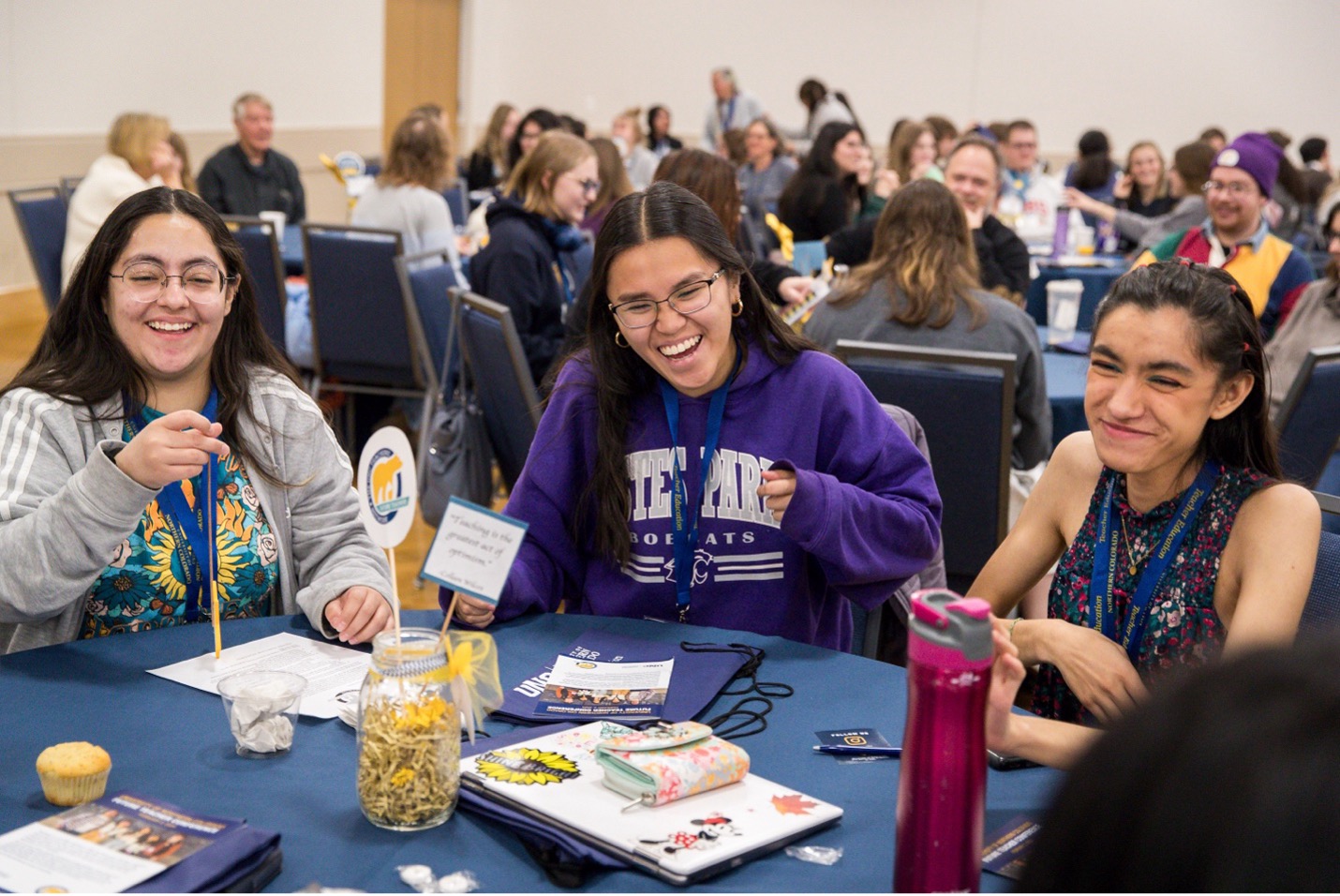 Three students at a roundtable laughing.