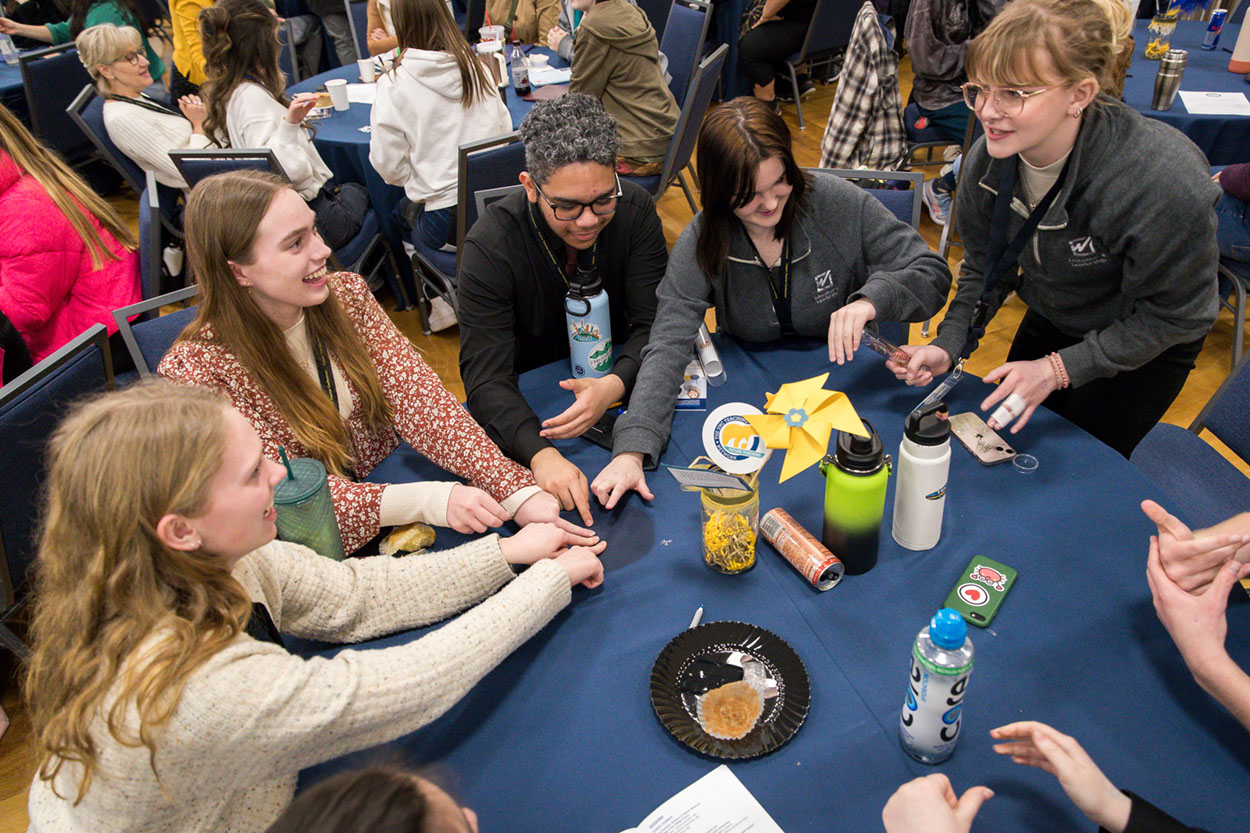 Group of students at a round table playing a game.