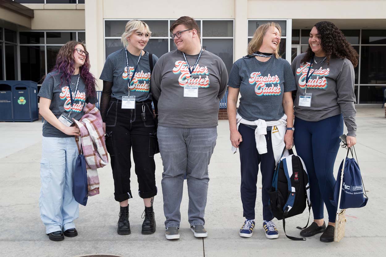 Group of Teacher Cadets smiling and looking at one another.