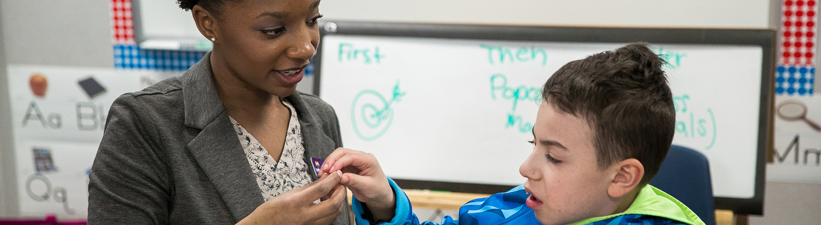 A teacher helps a special education student with their school work.