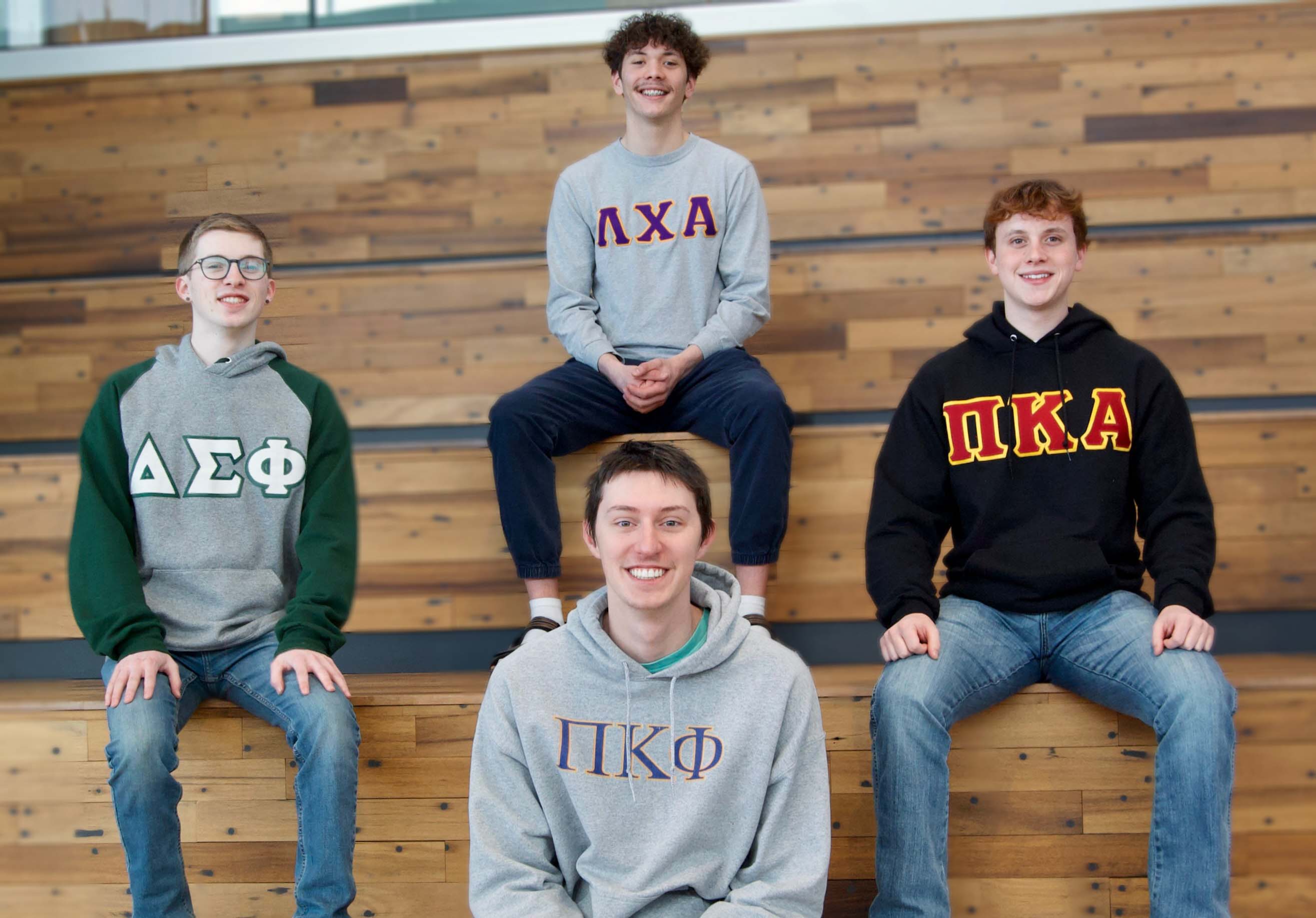 A group of NIC Fraternity members pose on a set of bleachers.
