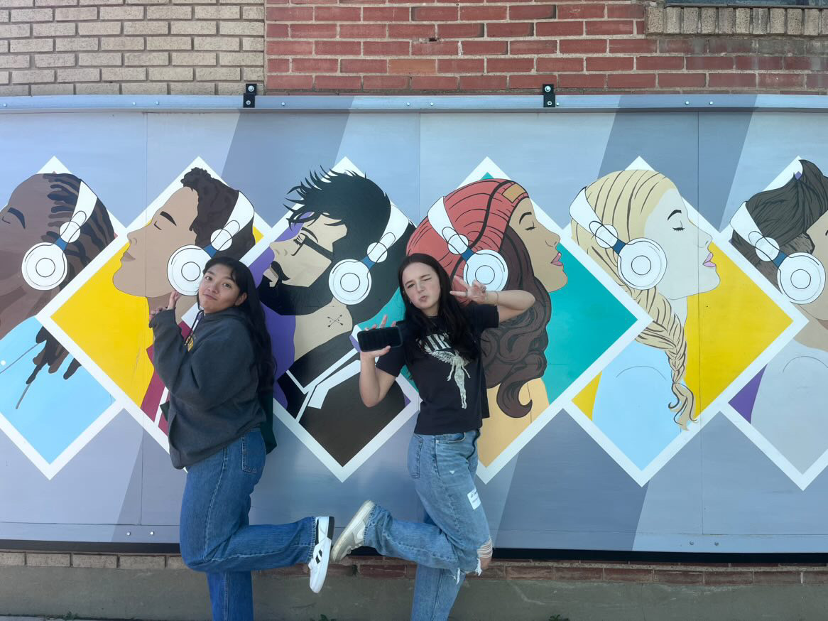 two honors students in front of a Greeley Mural