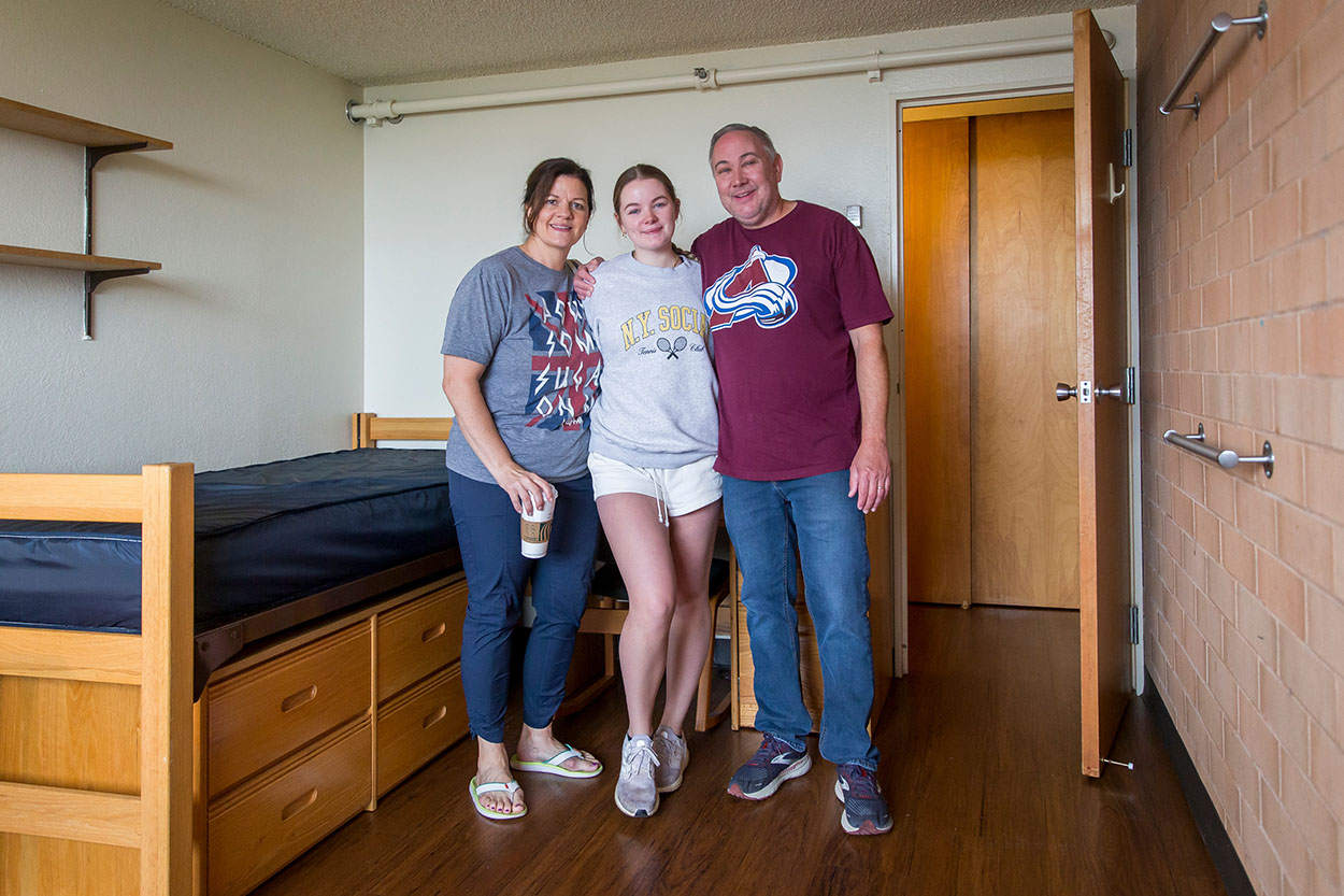 A family poses with their student in their new dorm room.