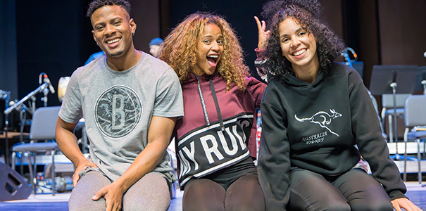 The three dancers smiling at the camera