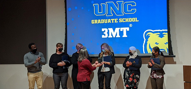 UNC graduate students standing on stage during spring 2022 research competition