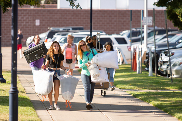 Students carrying loads of personal items during move in
