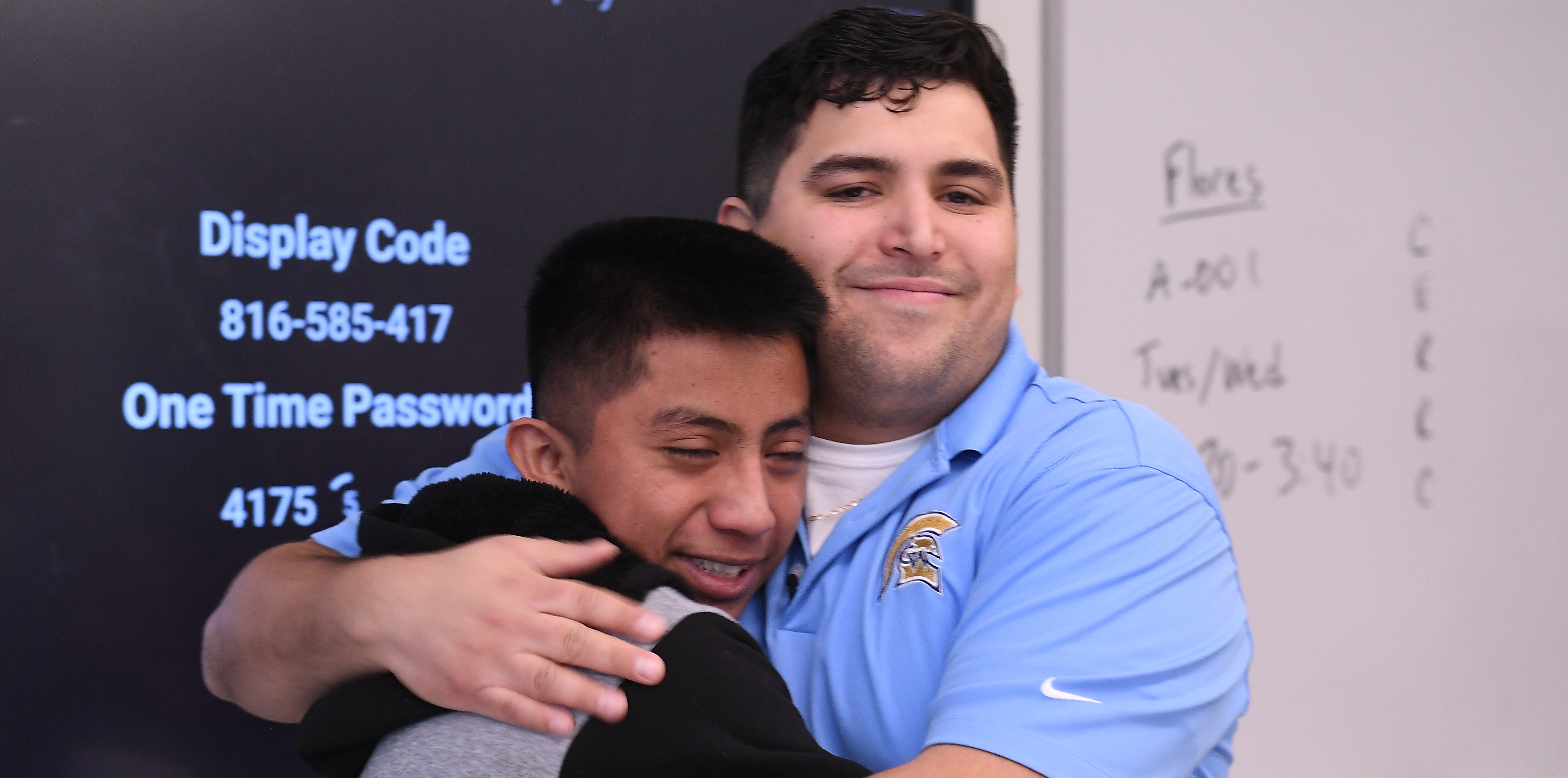 Caleb Flores hugging one of his male students