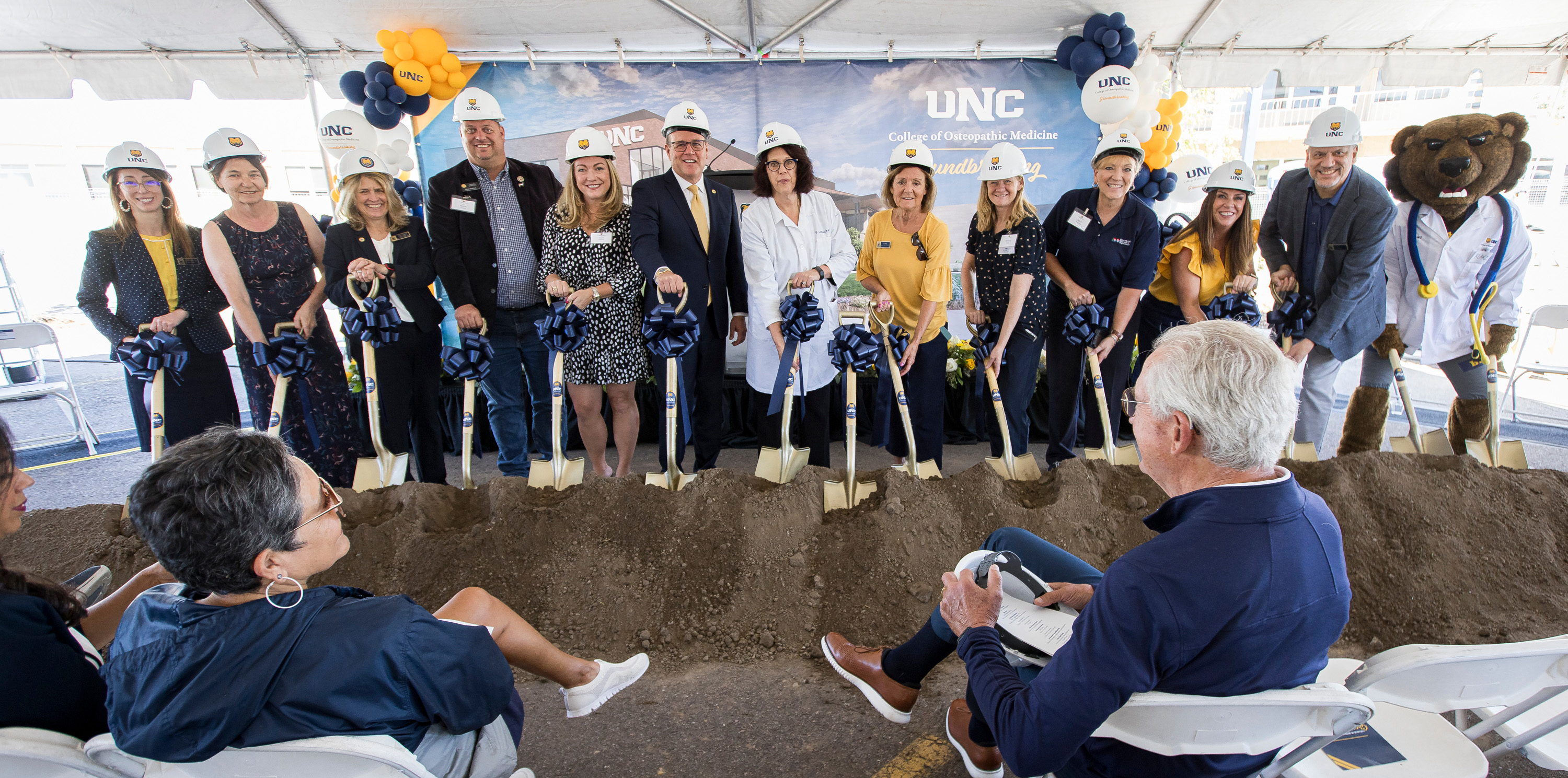 A group of adults holding gold shovels