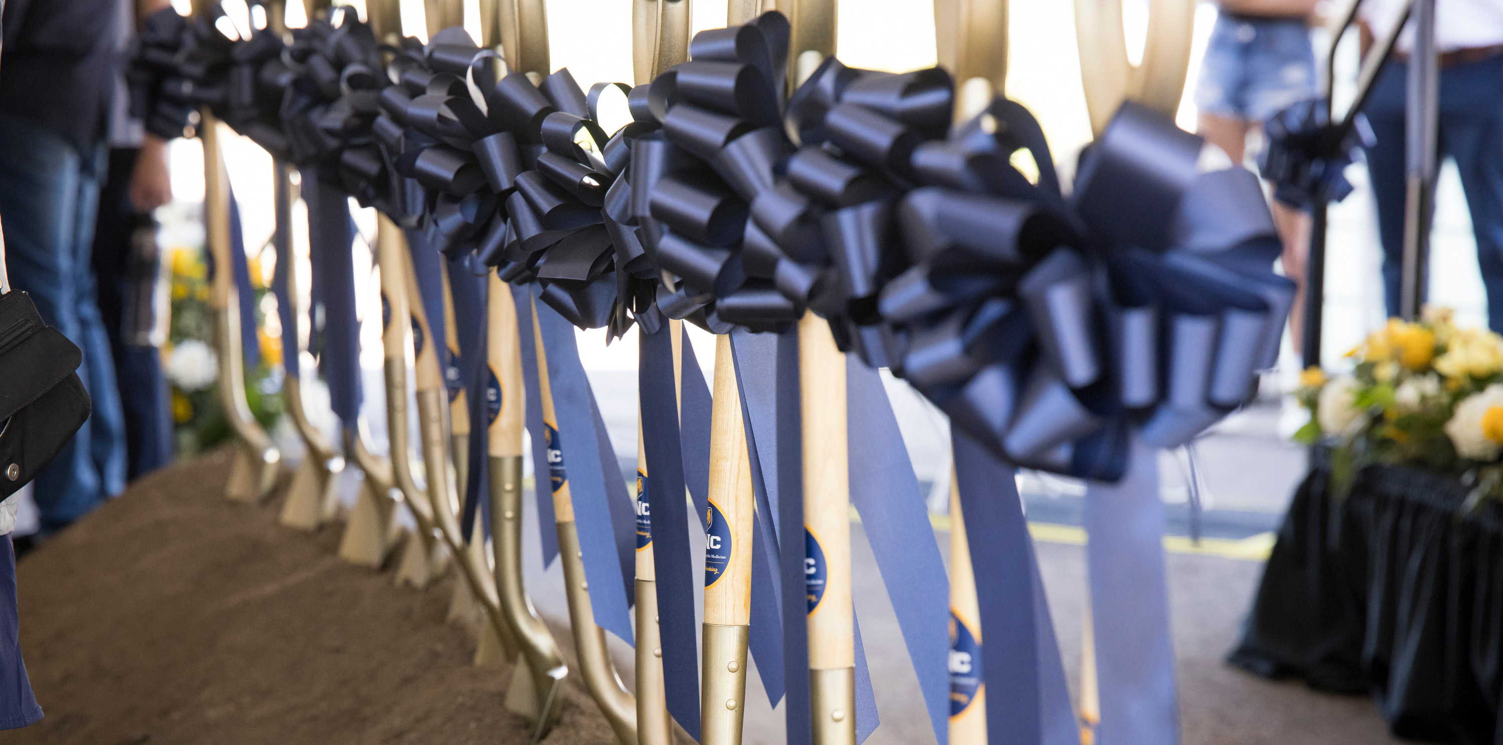 Gold shovels with blue bows on them