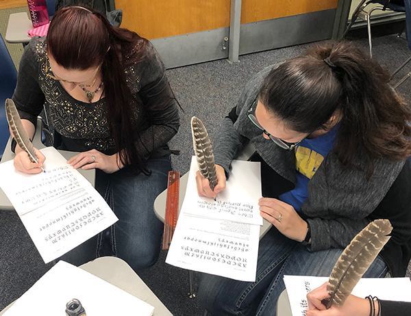 Other students using quills to write