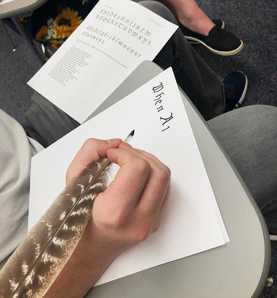 Student using a turkey feather quill to write