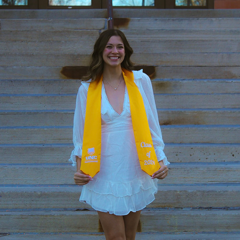 Katarina Cook wearing her graduation gown and smiling