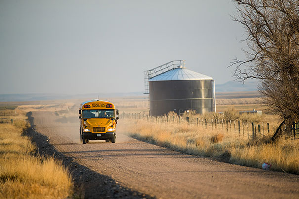 school bus driving on dirt road in rural Colorado