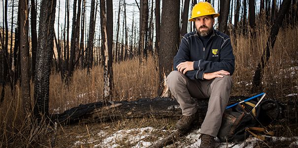 Scott Franklin poses in a burnt area from a previous wildfire