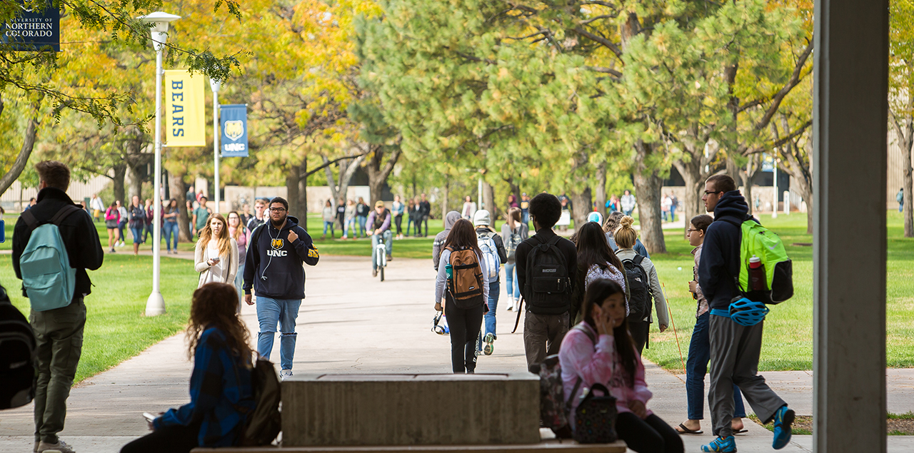 A crowd of UNC students walking on the sidewalks across campus.