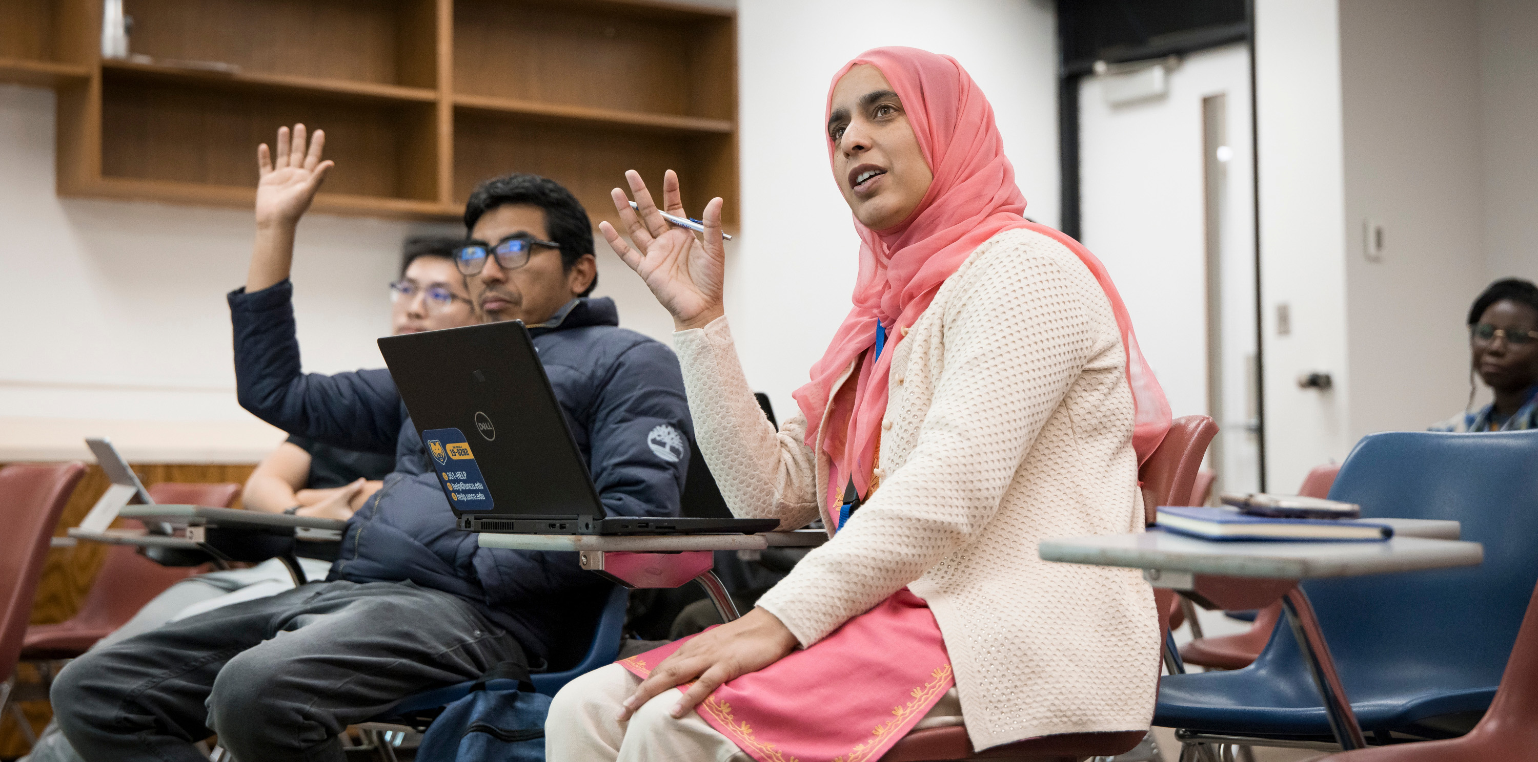 Two international teachers holding up their hands in the classroom