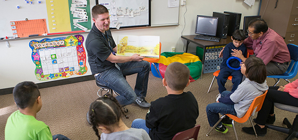 UNC student teacher reading to students in a classroom setting.