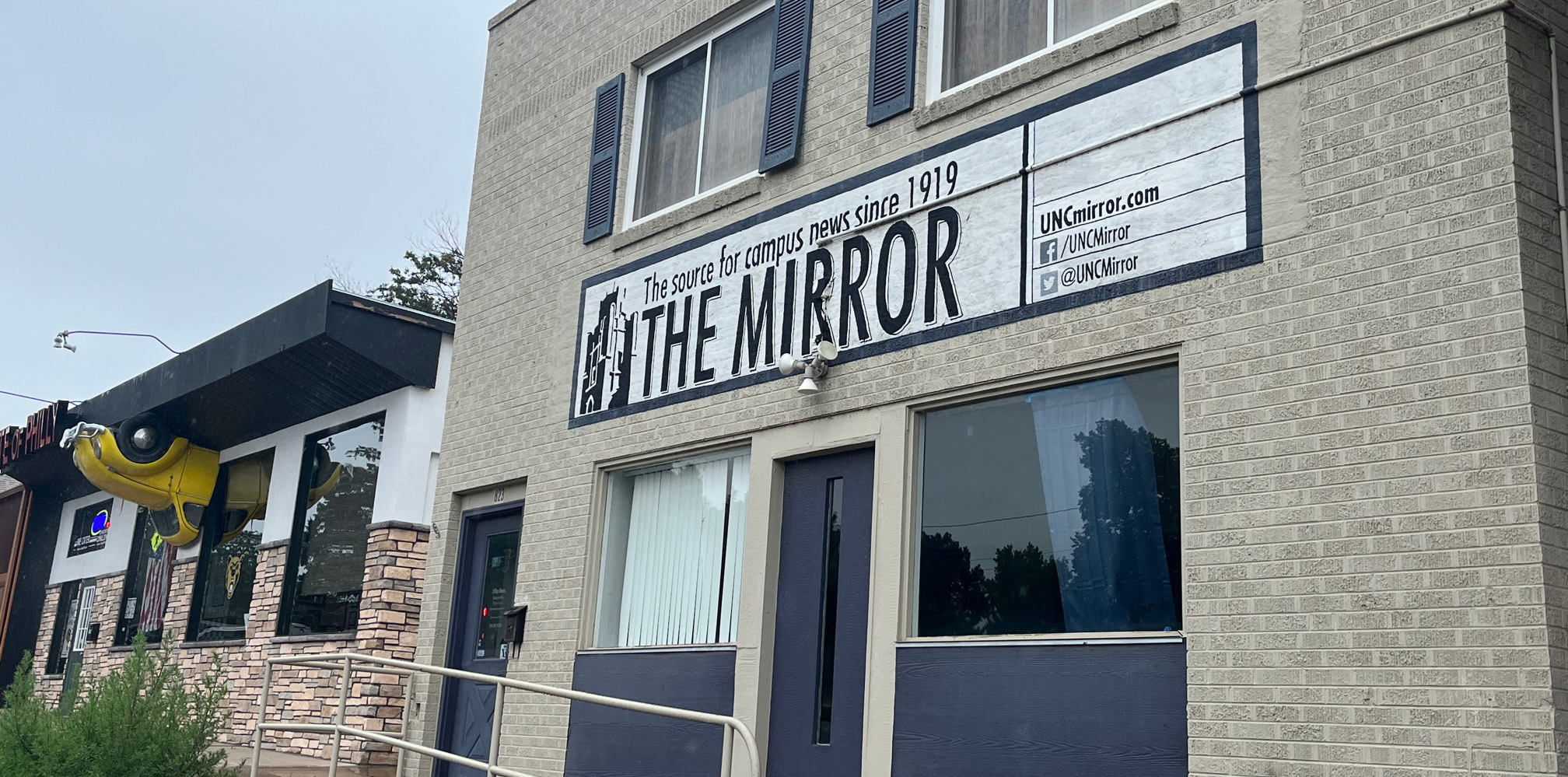 The outside of a building with a sign that says The Mirror, The source for campus news since 1919