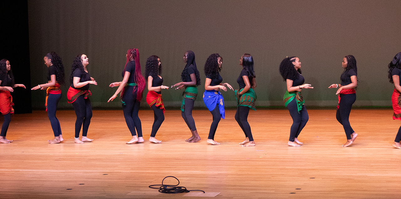 A group of women mid dance on a stage