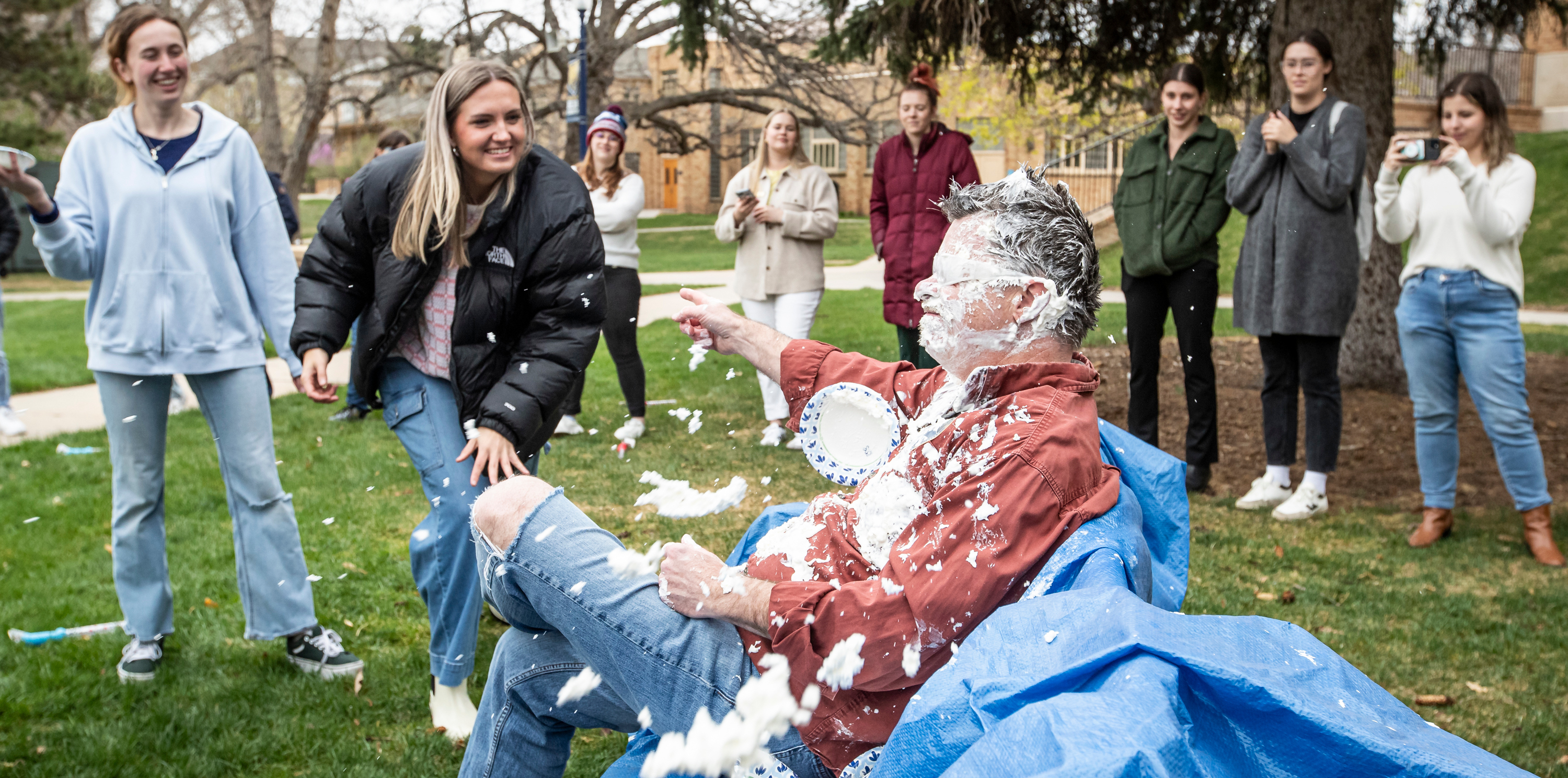 People light heartedly throwing a pie at a faculty member