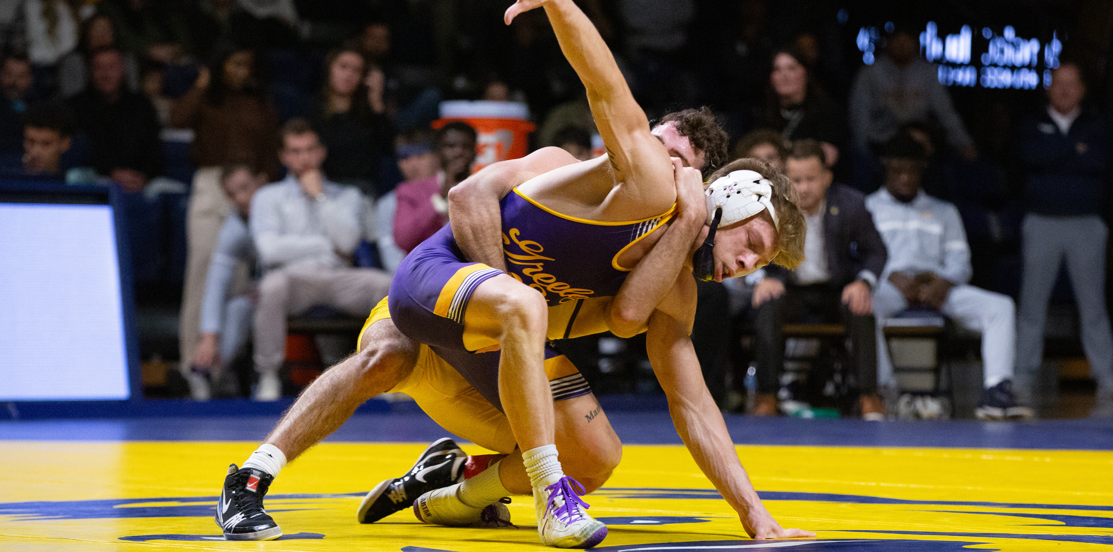 Two wrestlers in mid match on the matt