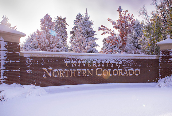 University of Northern Colorado brick sign covered in a dusting of snow.