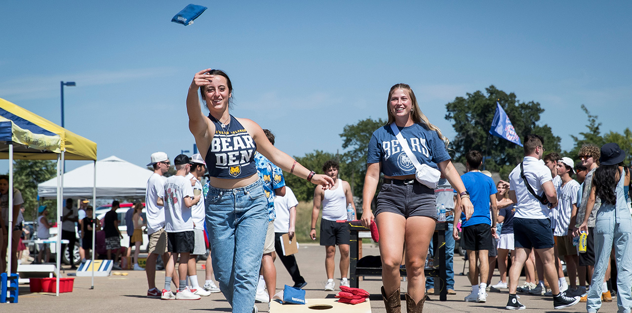 A UNC student throwing a bag playing cornhole