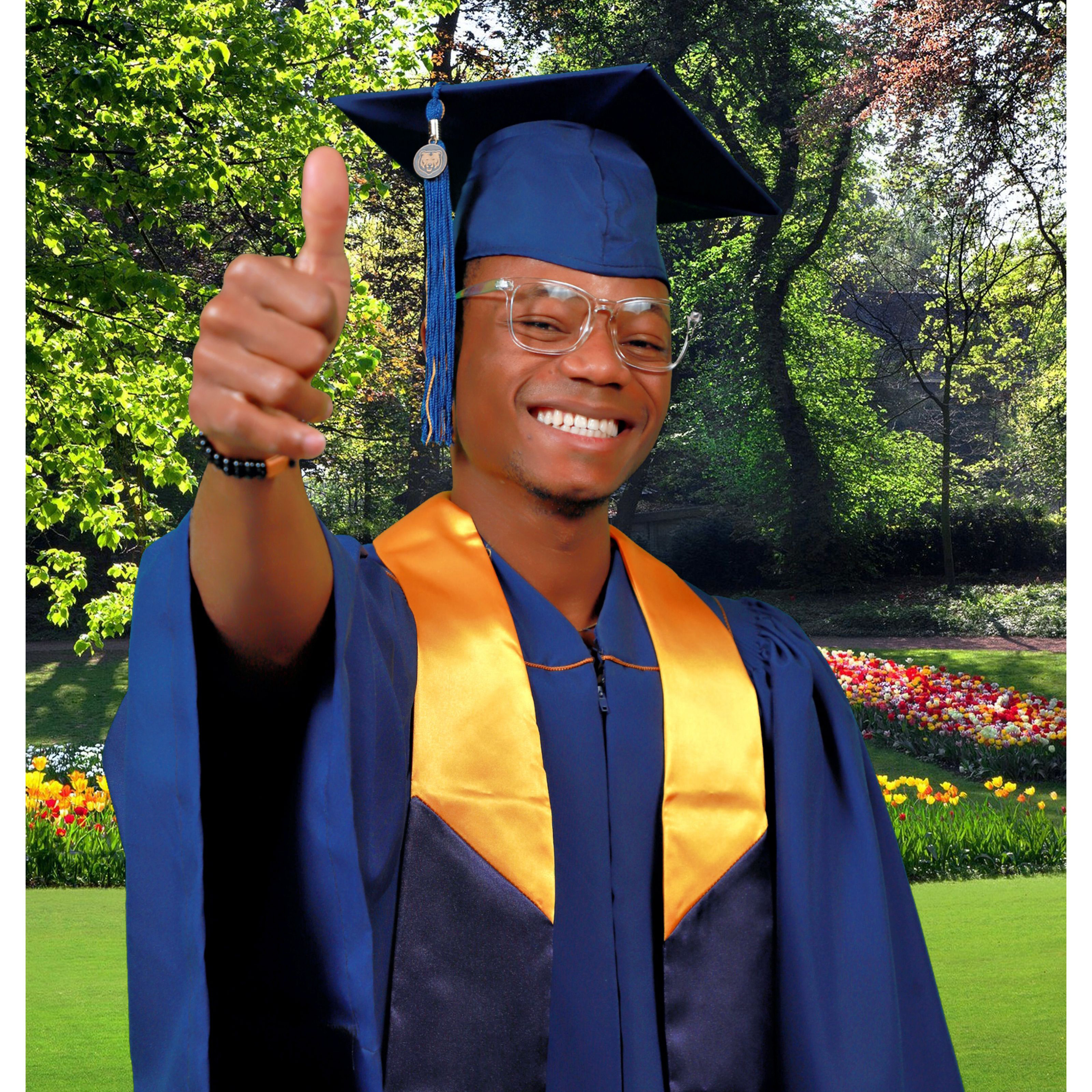 a student smiling with a graduation cap on and his hand holding up a thumbs up