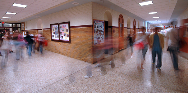 Timelapse photo of students walking around high school hallway