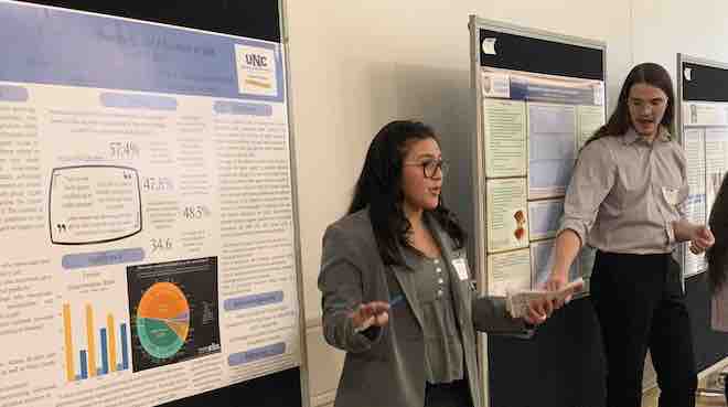 Image of two students presenting posters at Fall Symposium
