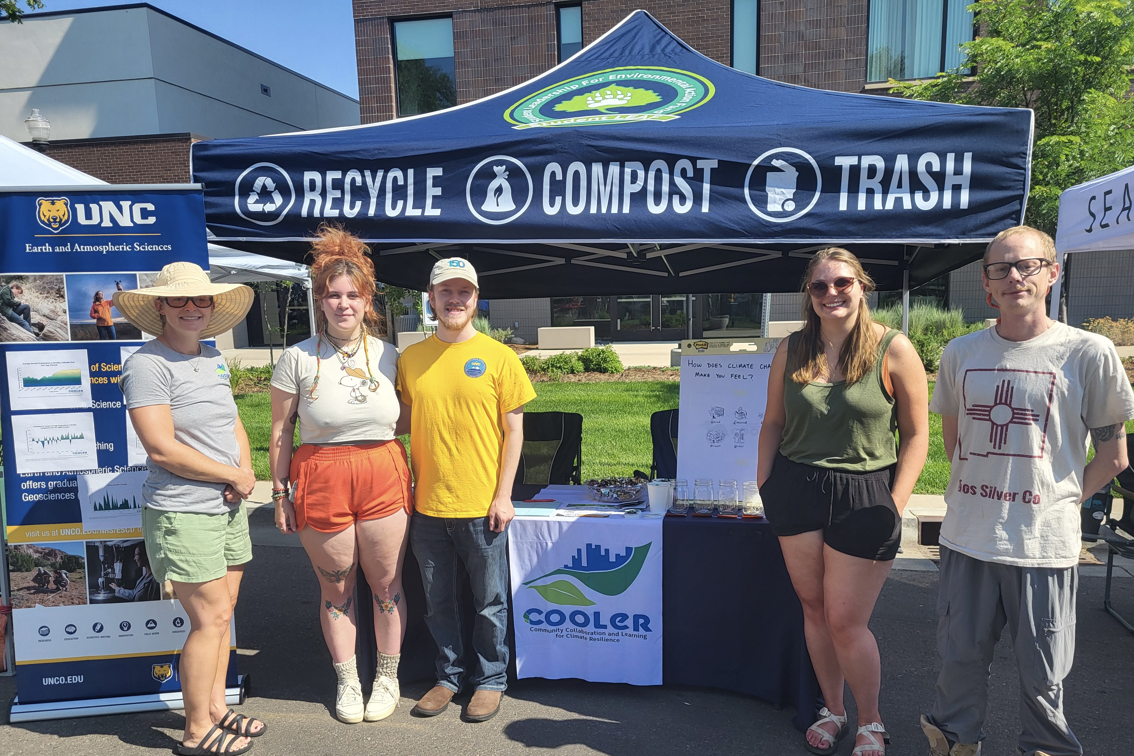 Lucinda Shellito, Sharon Bywater-Reyes, and Chelsea Romulo stand under their tent for the COOLER program.