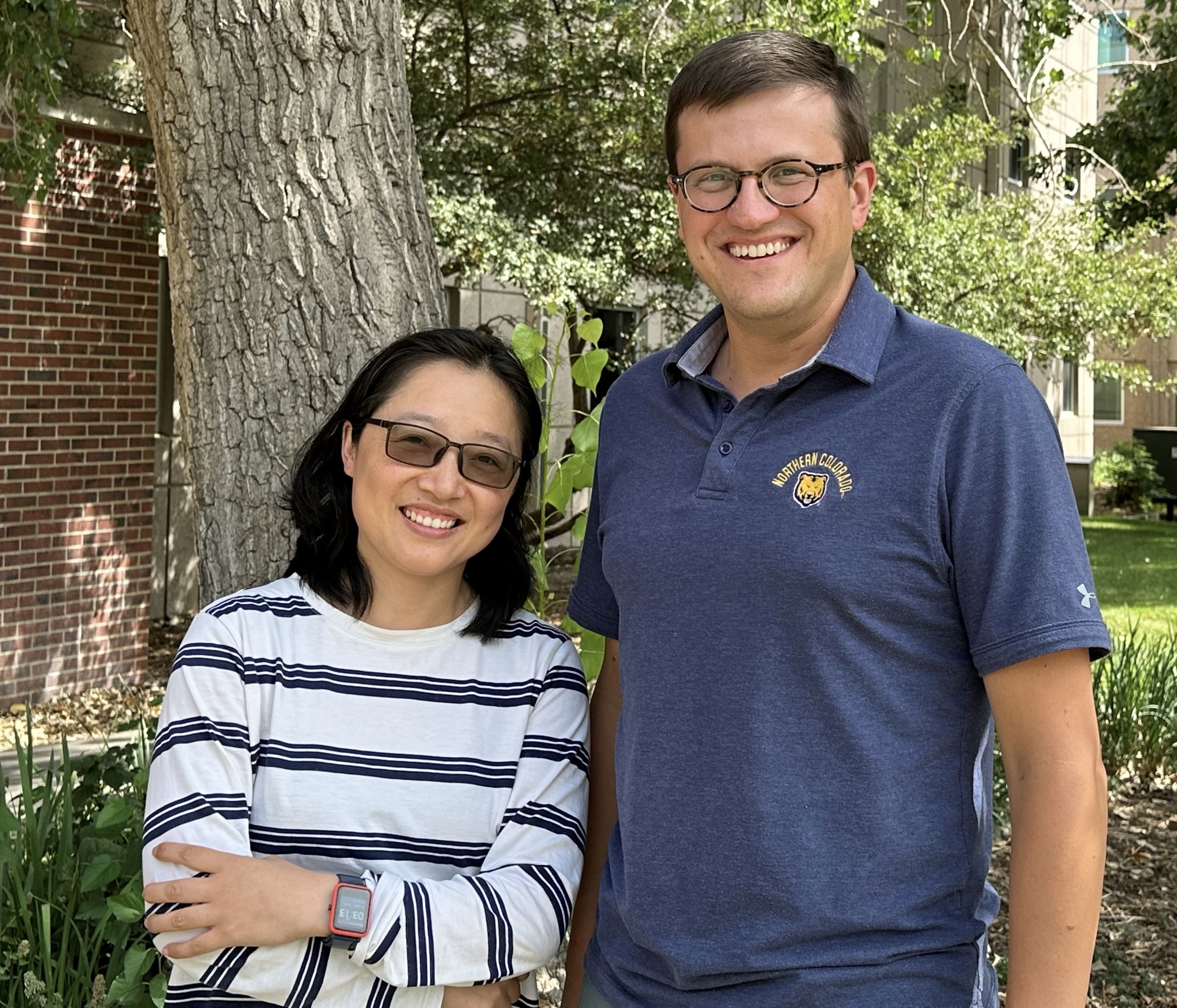 Yuyan Han and Nicholas Pullen Win pose for a photo in front of a tree.