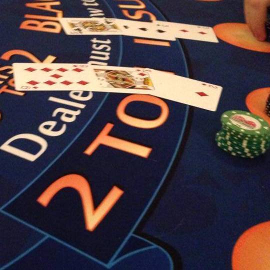 Card table displaying green poker chips and a two poker hands