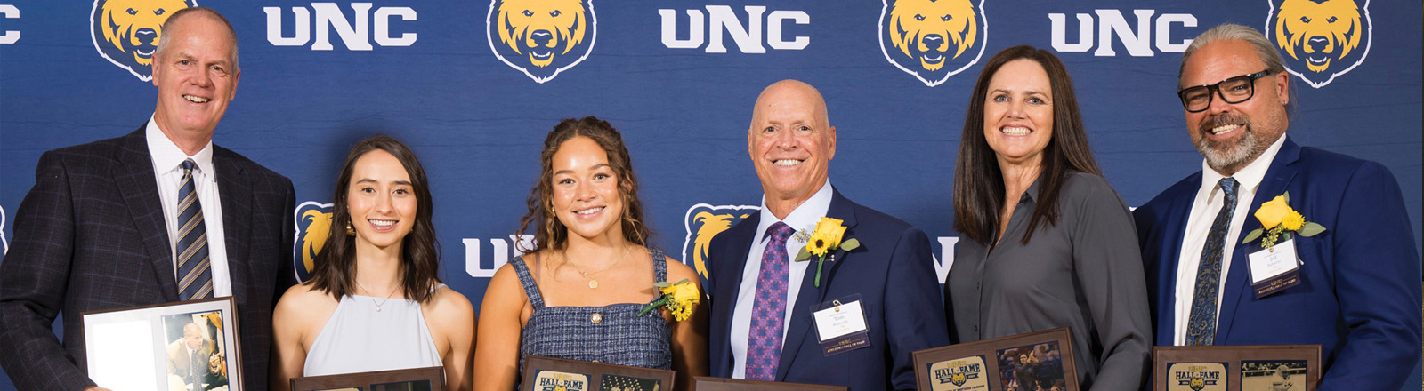 Athletic Hall of Fame receipients pose with their plaques.