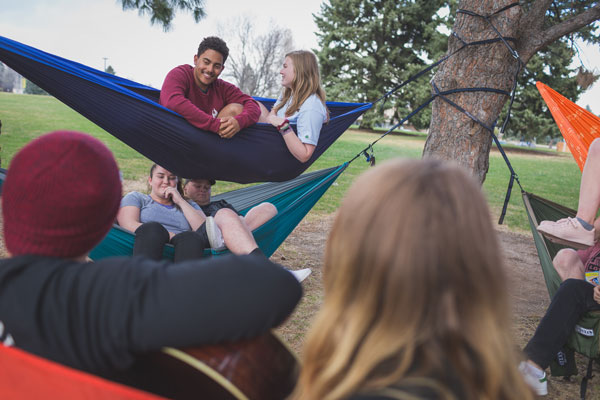 People sitting in hammocks strung from trees